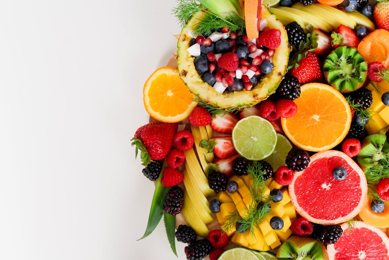 journey Colorful flat lay of assorted tropical fruits including pineapple, berries, and citrus.