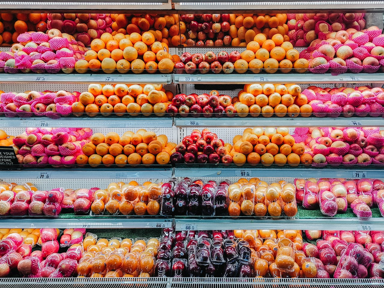 services-03 Colorful variety of fresh fruits neatly arranged on supermarket shelves, showcasing abundance and freshness.